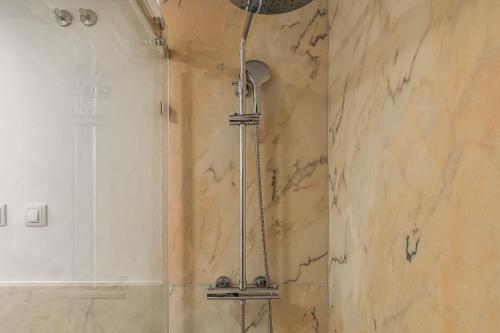 a shower in a bathroom with a marble wall at Beach House In Sesimbra in Sesimbra