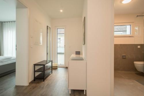 a white bathroom with a sink and a toilet at Ferienwohnung Arguna in Langenargen