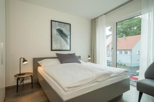 a bedroom with a bed and a large window at Ferienwohnung Arguna in Langenargen