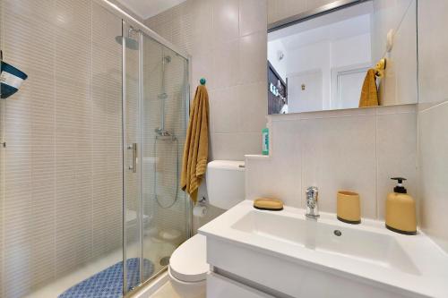 a white bathroom with a sink and a shower at The Studio - Pet friendly in Alvor