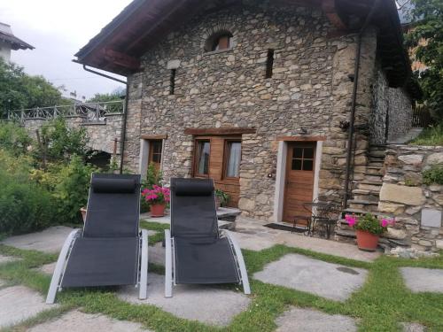 two chairs sitting in front of a stone house at Mini House Valle d'Aosta in Roisan