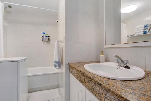 a white bathroom with a sink and a bath tub at Casa Isa in El Cotillo