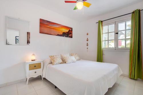 a white bedroom with a bed and a window at Casa Isa in El Cotillo