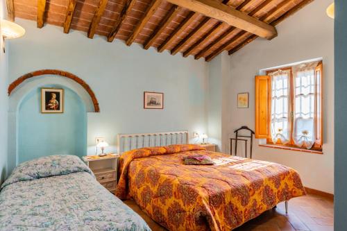 a bedroom with two beds and a window at Mulino di Beboli in Lamporecchio