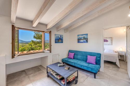 a living room with a blue couch and a window at Son del Rio Vell in Pollença