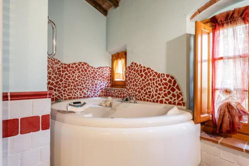 a bathroom with a sink and a toilet and a window at Mulino di Beboli in Lamporecchio