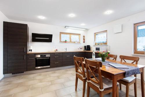 a kitchen with a wooden table and a dining room at Haus Morgensonne in Weilheim