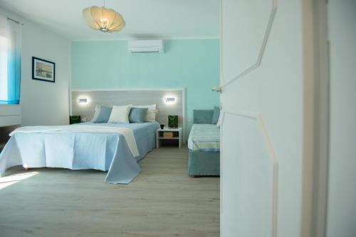 a white bedroom with a bed and a table at Casa Diamante Blu Mare in Marina di Campo