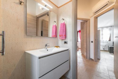 a bathroom with a white sink and a mirror at Villa Gloma in Capoterra