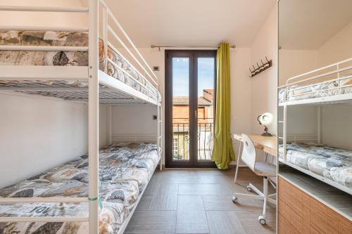 a dorm room with bunk beds and a desk at Villa Gloma in Capoterra