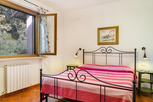 a bedroom with a bed with a red and white blanket at Bilo Gardenia in Marina di Grosseto