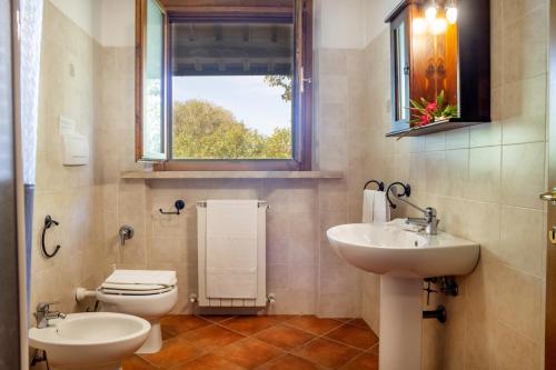 a bathroom with a sink and a toilet and a window at Bilo Gardenia in Marina di Grosseto