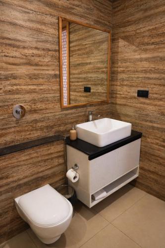 a bathroom with a toilet and a sink and a mirror at Atmosfera Bengaluru, India in Bangalore