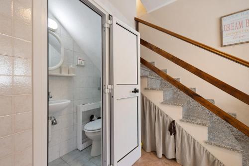 ein Badezimmer mit Toilette und eine Treppe in der Unterkunft Pocket House in Osiglia