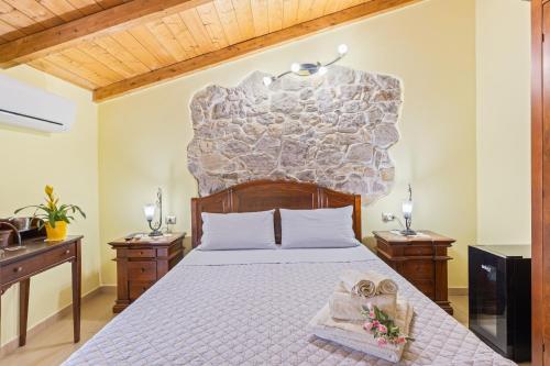 a bedroom with a bed with a stone wall at Affittacamere Le Muse in Scano Montiferro