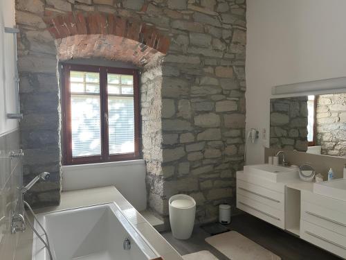 a bathroom with a tub and a stone wall at Burghaus in Bad Driburg