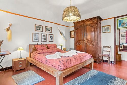 a bedroom with a large bed and a wooden cabinet at Villa Les Dauphins in Le Lavandou