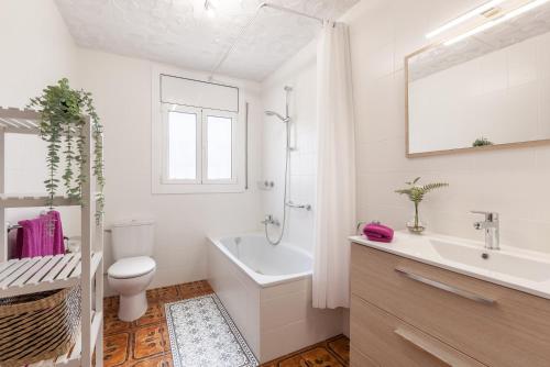 a white bathroom with a toilet and a sink at Apartamento Villa Mercedes in Rubí
