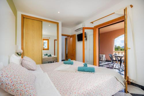 a bedroom with a large white bed with blue pillows at Casa Campillos in Llucmajor