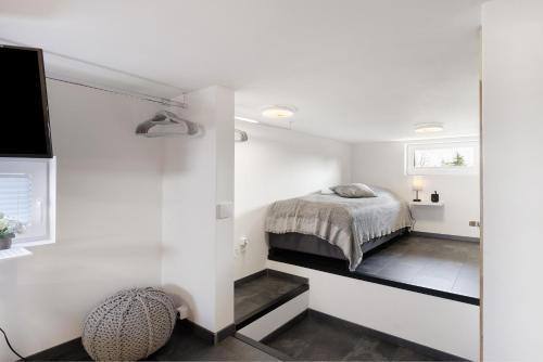 ein Schlafzimmer mit einem Bett in einem weißen Zimmer in der Unterkunft Happy-Nest in Oberkrämer