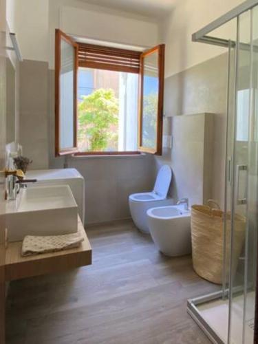 a bathroom with a sink and a toilet and a window at Via Verdi 14 in Mondolfo