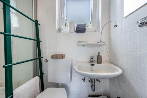 a white bathroom with a toilet and a sink at Ferienwohnung im Reiterparadies in Salzhausen