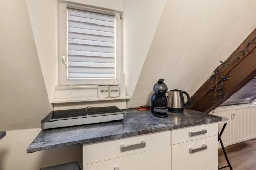 a kitchen with a counter top with a window at Gemütliches Appartament in Aldingen