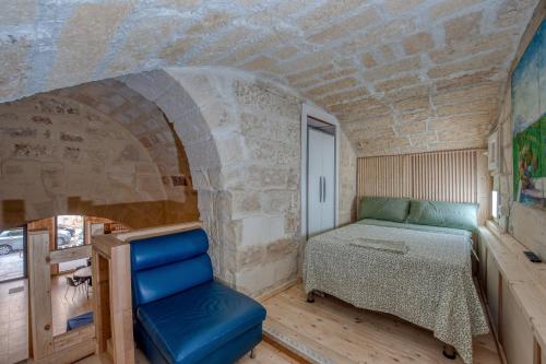 a small bedroom with a bed and a chair at San Leonardo Apartments in Lecce