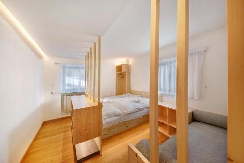 a small bedroom with a bed and a staircase at Roda A Parte in Vigo di Fassa