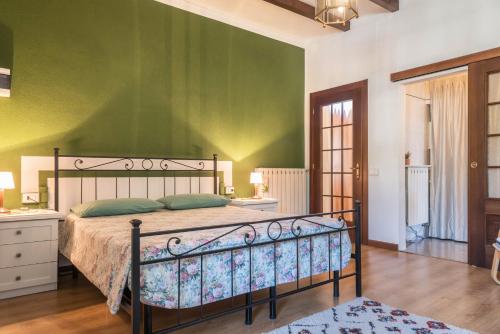 a bedroom with a bed and a green wall at Tinas yellow home in Leggiuno
