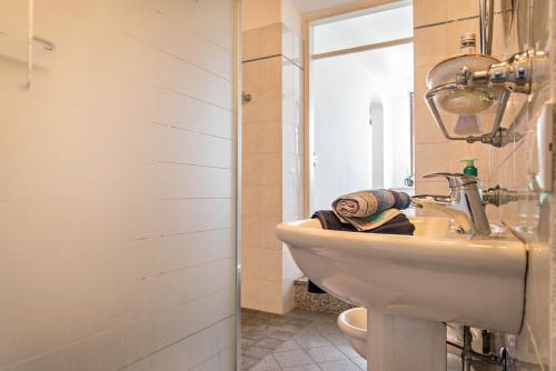 a bathroom with a sink and a toilet at Tinas yellow home in Leggiuno