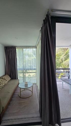 a room with a bed and a table and a large window at joyful the Kris202 in Ban Lum Fuang