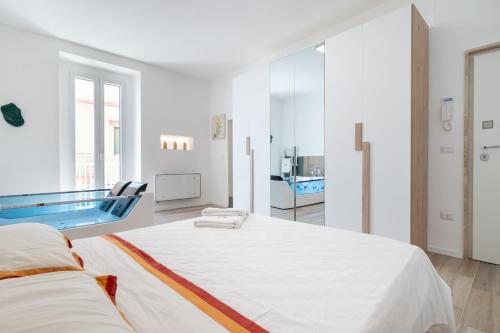 a white bedroom with a large bed and a swimming pool at Suite N12 - Luxury Apartment in Bari
