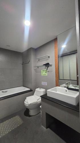 a bathroom with a toilet and a sink and a tub at joyful the Kris202 in Ban Lum Fuang
