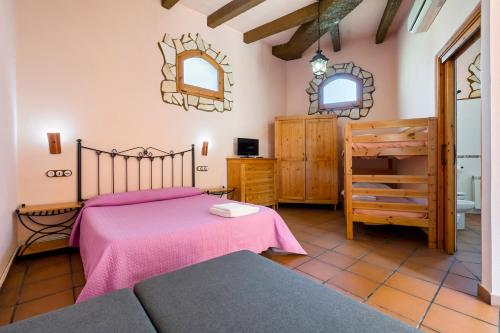 a bedroom with a bed and a couch in a room at La Xaconera in Catllar