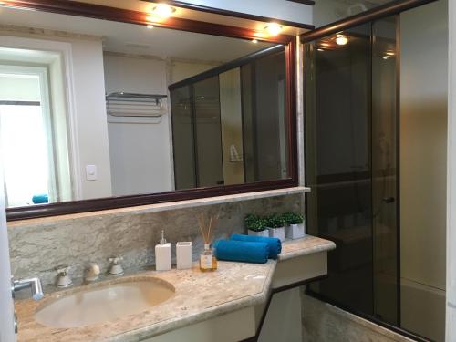y baño con lavabo y ducha con espejo. en Apartamento confortável - Jd Paulista, en São Paulo