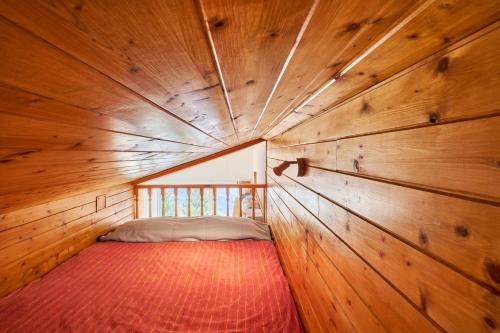 a small room with a bed in a wooden cabin at Appartement Avec Balcon St Honore in Saint-Honoré