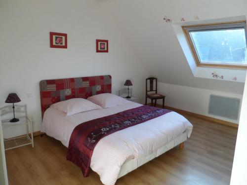 a bedroom with a bed and a window in it at Gite bord de mer jacuzzi in Plougrescant