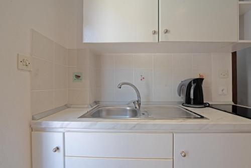 a kitchen with a sink and a microwave at Andromaches apartment sea view in Corfu