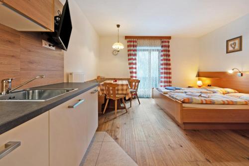 a kitchen and living room with a bed and a table at Heiserhof App Holunder in Racines