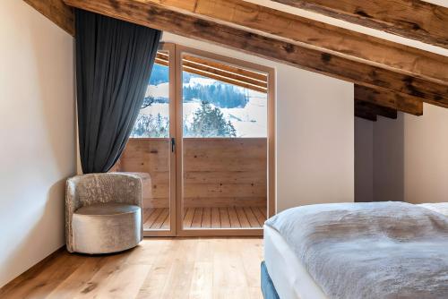 a bedroom with a bed and a sliding glass door at Chalet’s Samer in Sarntal