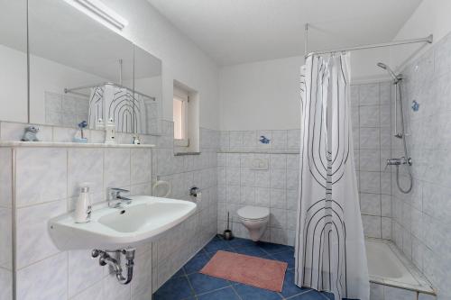 a white bathroom with a sink and a shower at Nichtraucher-Ferienwohnung Sandhaas in Ringsheim