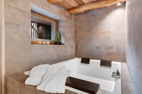 a bathroom with a white tub and a sink at Chalet’s Samer in Sarntal