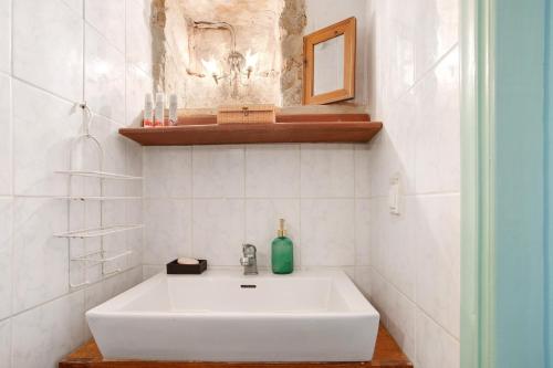 a white sink in a white tiled bathroom at Sira Stonehouse lll in Volímai