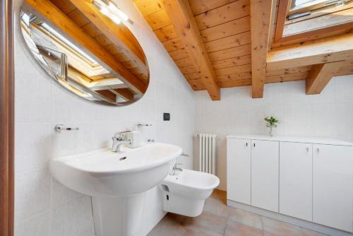 a white bathroom with a sink and a mirror at Residence Bardolino in Bardolino