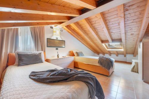 a bedroom with two beds in a room with wooden ceilings at Residence Bardolino in Bardolino