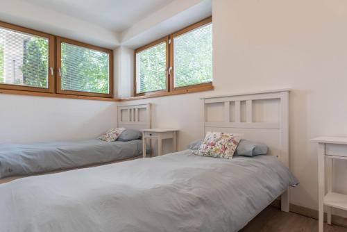 two beds in a room with windows at Casa Weekend in Revò