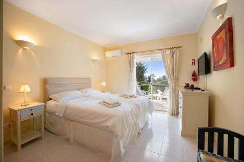 a bedroom with a large bed and a balcony at Casa Primavera in Carvoeiro