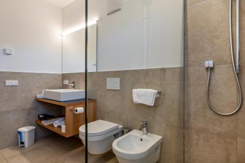 a bathroom with a shower and a toilet and a sink at Ferienwohnungen Karin - Lagrein in Termeno
