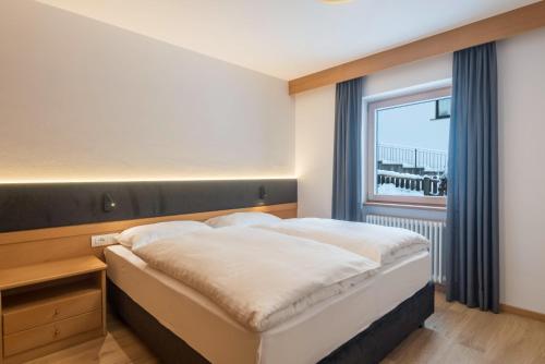 a bedroom with a large bed and a window at La Grambla App Sella in Santa Cristina Gherdëina
